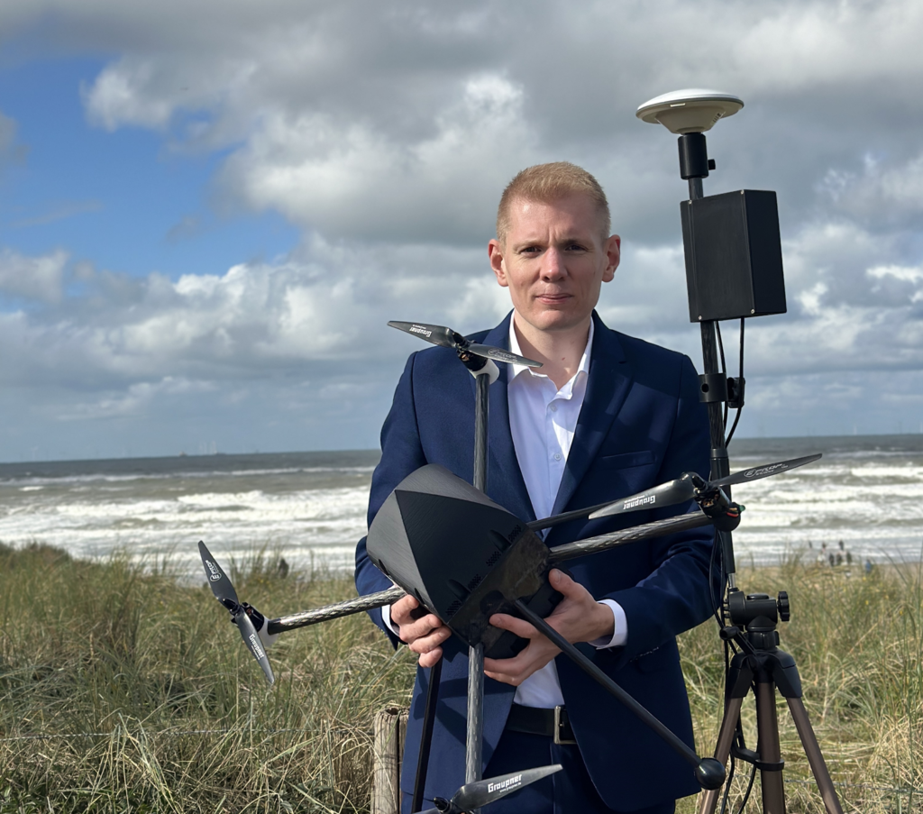 space business entrepreneur holding robotic aerial scanner on a beach 