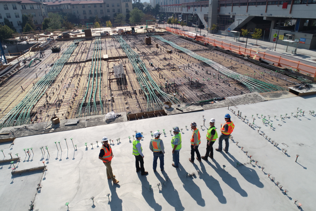 people with hard hats stood by construction site with exposed cables