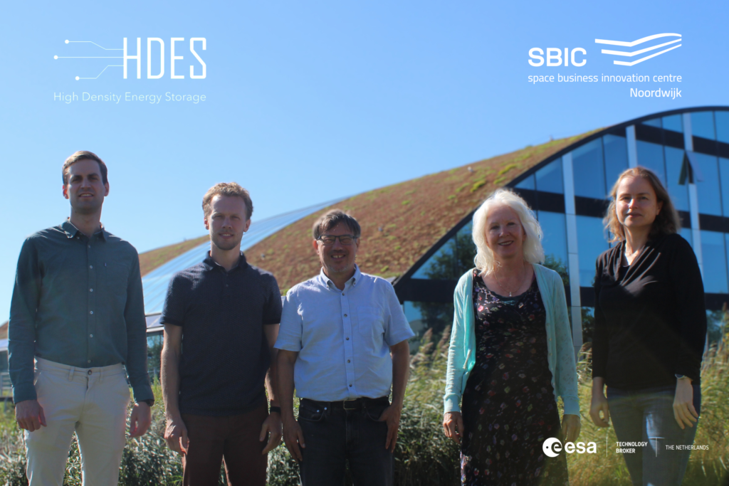 team of space tech engineers under blue sky near the SBIC Noordwijk curved-roof building